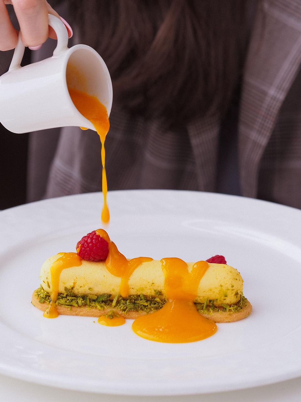 saucydessert person pouring sauce over dessert